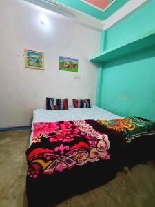 a bedroom with a bed with a colorful blanket on it at Mishra villa in Prayagraj