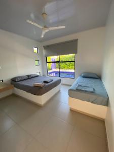 a bedroom with two beds and a window at Casa de campo D&G in Carmen de Apicalá