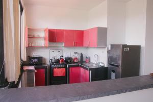 eine Küche mit roten Schränken und einem schwarzen Kühlschrank in der Unterkunft Charm & Confort - Tarapoto - Peru in Tarapoto + 16 Fotos