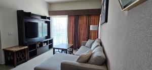 a living room with a couch and a television at Departamento Torre Iberika Cercas Del Malecon in Mazatlán