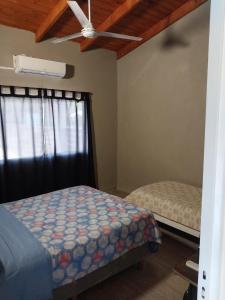 Schlafzimmer mit einem Bett und einem Fenster mit einem Deckenventilator in der Unterkunft Quinta Don Mario in Riachuelo