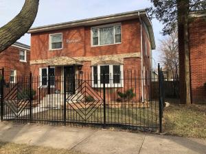 a black fence in front of a brick house at The Marlowe, A Couples Getaway in Chicago