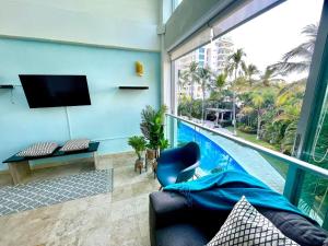 a living room with a tv and a swimming pool at Depto 2 Pisos, Vista Alberca. A 50 mts Del Mar in Nuevo Vallarta 