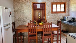 una cucina con un tavolo di legno con sedie e un frigorifero di Casa Rústica Próxima ao Distrito de Milho Verde, 3 QUARTOS - São Gonçalo do Rio das Pedras, Serro a Sêrro