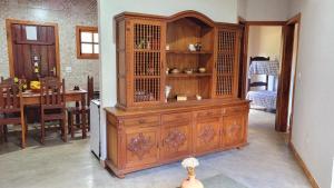 un grande mobile in legno in una stanza con sala da pranzo di Casa Rústica Próxima ao Distrito de Milho Verde, 3 QUARTOS - São Gonçalo do Rio das Pedras, Serro a Sêrro