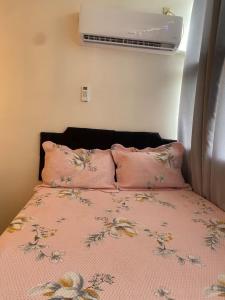 a bedroom with a bed with pink sheets and pillows at Flat Aconchegante in Goiânia