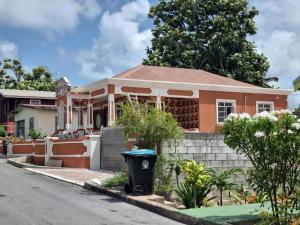 a house with a trash can in front of it at Historic Manor in Bridgetown