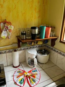 a kitchen with a counter with a shelf with pots and pans at Costa Rica Getaway in Jacó