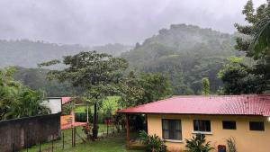 a house with a red roof in front of a mountain at Costa Rica Getaway in Jacó +2 photos