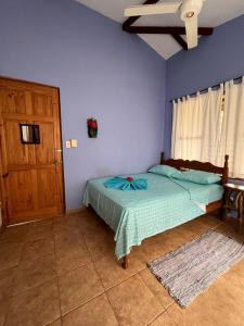 a blue bedroom with a bed and a wooden door at Costa Rica Getaway in Jacó