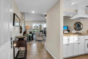 a kitchen with white cabinets and a living room at PD Resorter 2BR with Golf course views in Palm Desert
