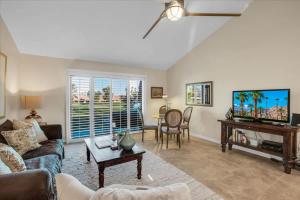 a living room with a couch and a tv at PD Resorter 2BR with Golf course views in Palm Desert