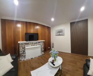 a living room with a couch and a tv at Quite and friendly house in Noble Park +2 photos