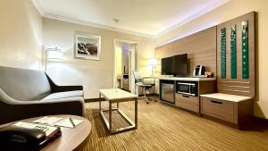 a hotel room with a couch and a desk at Quality Inn & Suites Los Angeles Airport - Stadium District in Inglewood