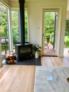 sala de estar con chimenea y estufa de leña en Lake Daylesford Villa2 Lake frontage pet friendly, en Daylesford