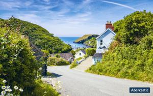 une rue avec des maisons sur une colline à côté de l'océan dans l'établissement Tri Pysgodyn, à Haverfordwest