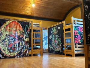 Zimmer mit 3 Etagenbetten und Gemälden an den Wänden in der Unterkunft 버킷 제주 - Bucket Jeju in Seogwipo
