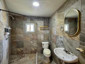 a bathroom with a toilet and a sink and a mirror at Casa Palma in Xochitepec