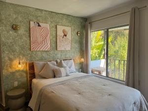 a bedroom with a bed and a large window at Casa Palma in Xochitepec