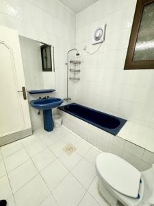 a bathroom with a toilet and a blue sink at Rest house in Abha +17 photos