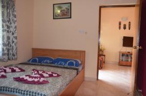 a bedroom with a bed and a room with a television at BBN Serviced Apartment in Calangute