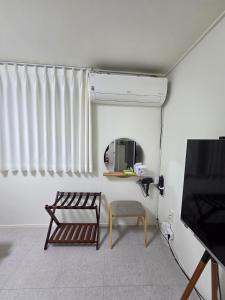 a living room with a chair and a mirror at Dodam Stay in Seoul