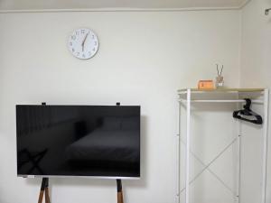 a clock on a wall next to a flat screen tv at Dodam Stay in Seoul +14 photos