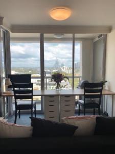 a room with a desk with chairs and a large window at Darling Harbour Luxurious Retreat in Sydney