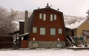 a house with snow on the ground in front of it at Coalition Lodge in Park City