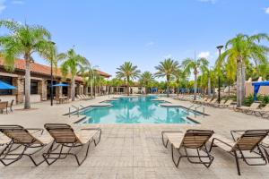 una piscina con sedie e palme di Show Stopping 5bdr45bath Villa Wpool a Davenport
