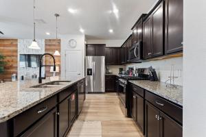 una cucina con mobili neri e un frigorifero in acciaio inossidabile di Show Stopping 5bdr45bath Villa Wpool a Davenport