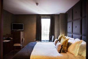 a hotel room with a large bed and a window at San Pietro Hotel & Restaurant in Scunthorpe