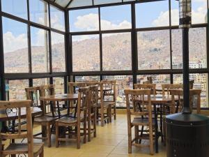 a restaurant with tables and chairs in front of a window at Bolivian Heights Hostel in La Paz
