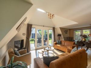 Holiday Home Groote Keeten near Beaches في جروت كيتين: غرفة معيشة بها أريكة وطاولة