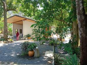 a woman walking in front of a building with trees at Ingtara at Lanta in Ko Lanta