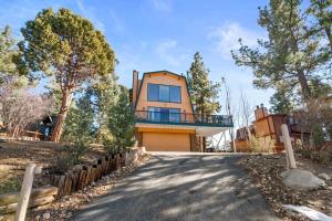 ein Haus mit einer Auffahrt davor in der Unterkunft The Cedar Bear Lodge, Jacuzzi with an Outdoor Patio & BBQ in Big Bear City Airport