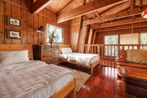 ein Schlafzimmer mit einem Bett und einem Sofa in einer Hütte in der Unterkunft The Cedar Bear Lodge, Jacuzzi with an Outdoor Patio & BBQ in Big Bear City Airport