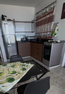 a kitchen with a table with chairs and a microwave at Frente mar, pé na areia !! in Praia Grande