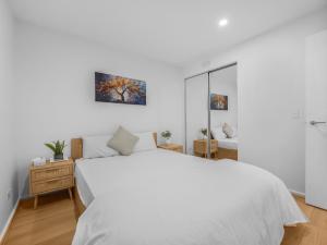 メルボルンにある37th Floor City Views Luxury Apartment and Parkingの白いベッドルーム(白いベッド1台、鏡付) +16枚の写真