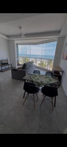 a living room with a table and chairs and a couch at Frente mar, pé na areia !! in Praia Grande +3 photos