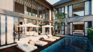 a house with a pool with white furniture and windows at The One Boutique Villa in Seminyak