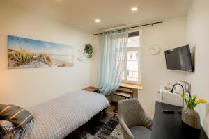 a bedroom with a bed and a tv and a window at Hotel Restaurant Syrtaki in Gernsbach