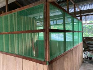 a green glass window in a wooden building at centro cultural yoi e ipi in Macedonia