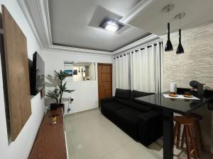 un salon avec un canapé noir et une table dans l'établissement Apartamento com Vista Única e Maravilhosa !!!, à São Vicente