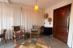 a living room with two chairs and a door at Serra de Aruna in Pirenópolis