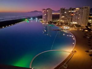 a pool at night with a beach and buildings at LA SERENA- Laguna del Mar in La Serena +14 photos