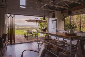 a kitchen with a view of a table with an umbrella at Braelee Bower in Rollands Plains