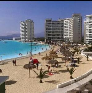 a beach with people on the sand and buildings at LA SERENA- Laguna del Mar in La Serena