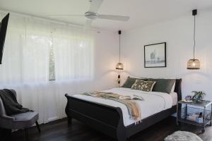 a bedroom with a large bed and a chair at Braelee Bower in Rollands Plains