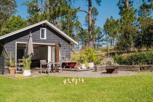 a small shed with a table and a patio at Braelee Bower in Rollands Plains
